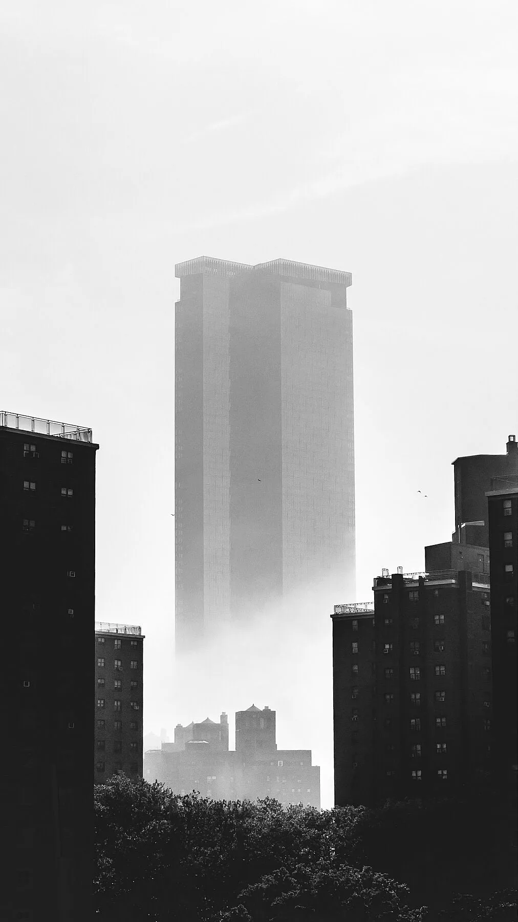 Dystopian scenes of the imposing One Manhattan Square building looming above the fog