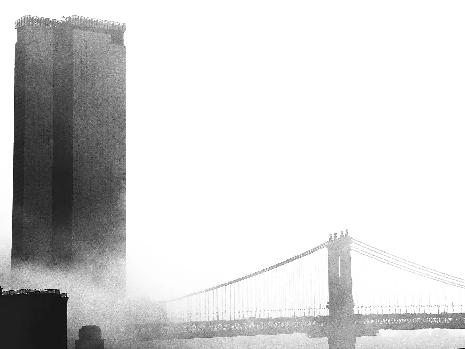 The ominous looking One Manhattan Square, overshadowing Manhattan Bridge on a foggy morning.